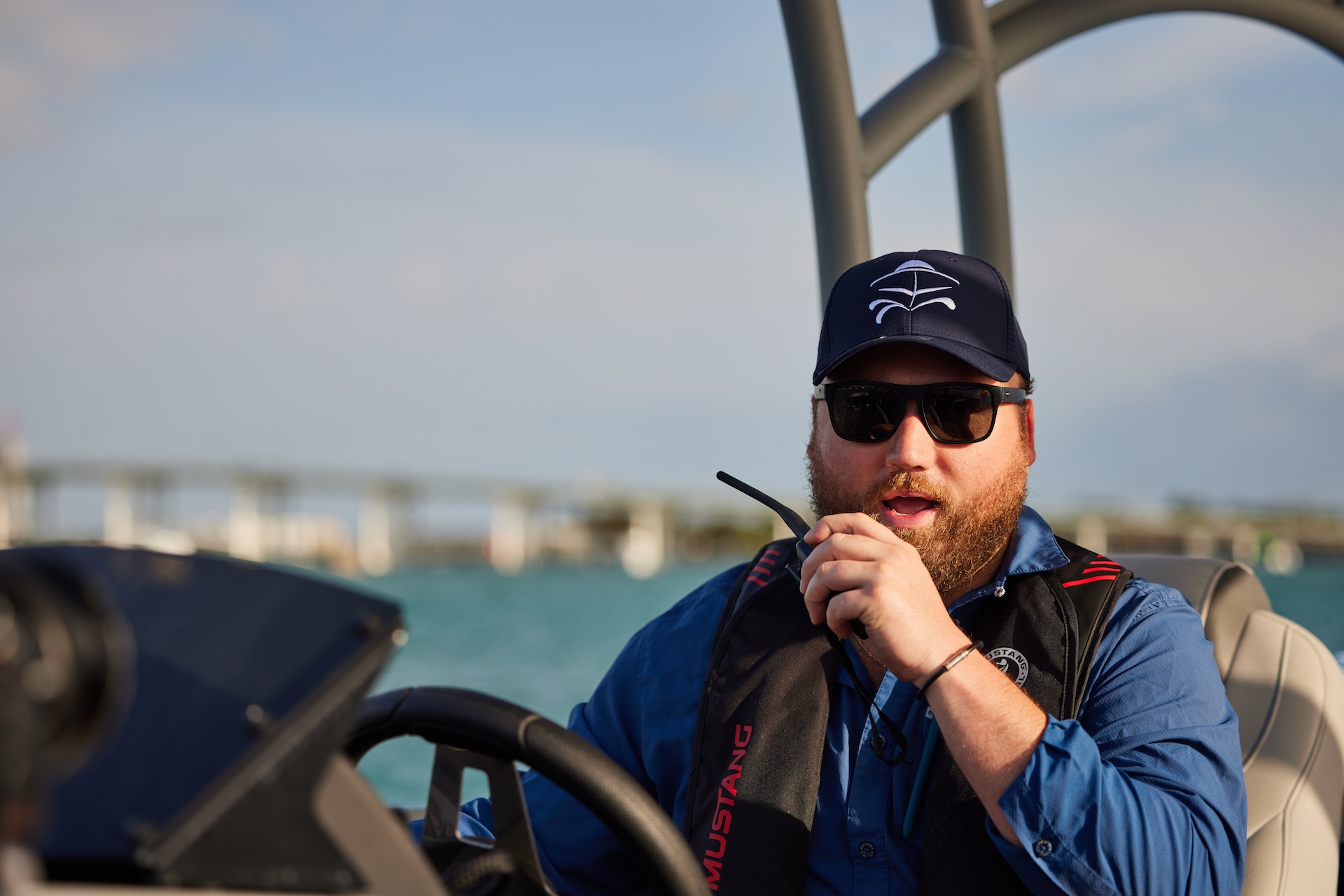 Man drives boat and uses radio, what to do when someone falls overboard concept.