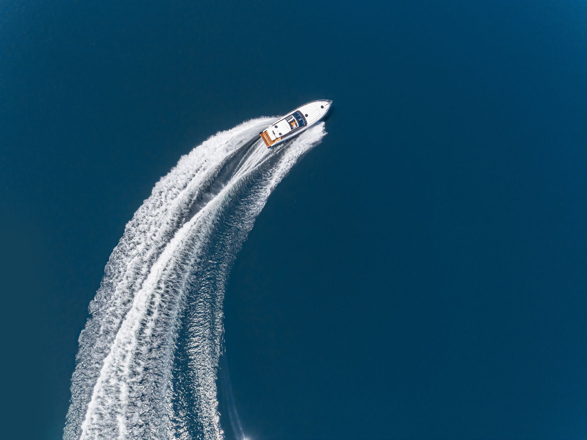 Overhead view of boat turning, what should you always do when a person falls overboard concept.