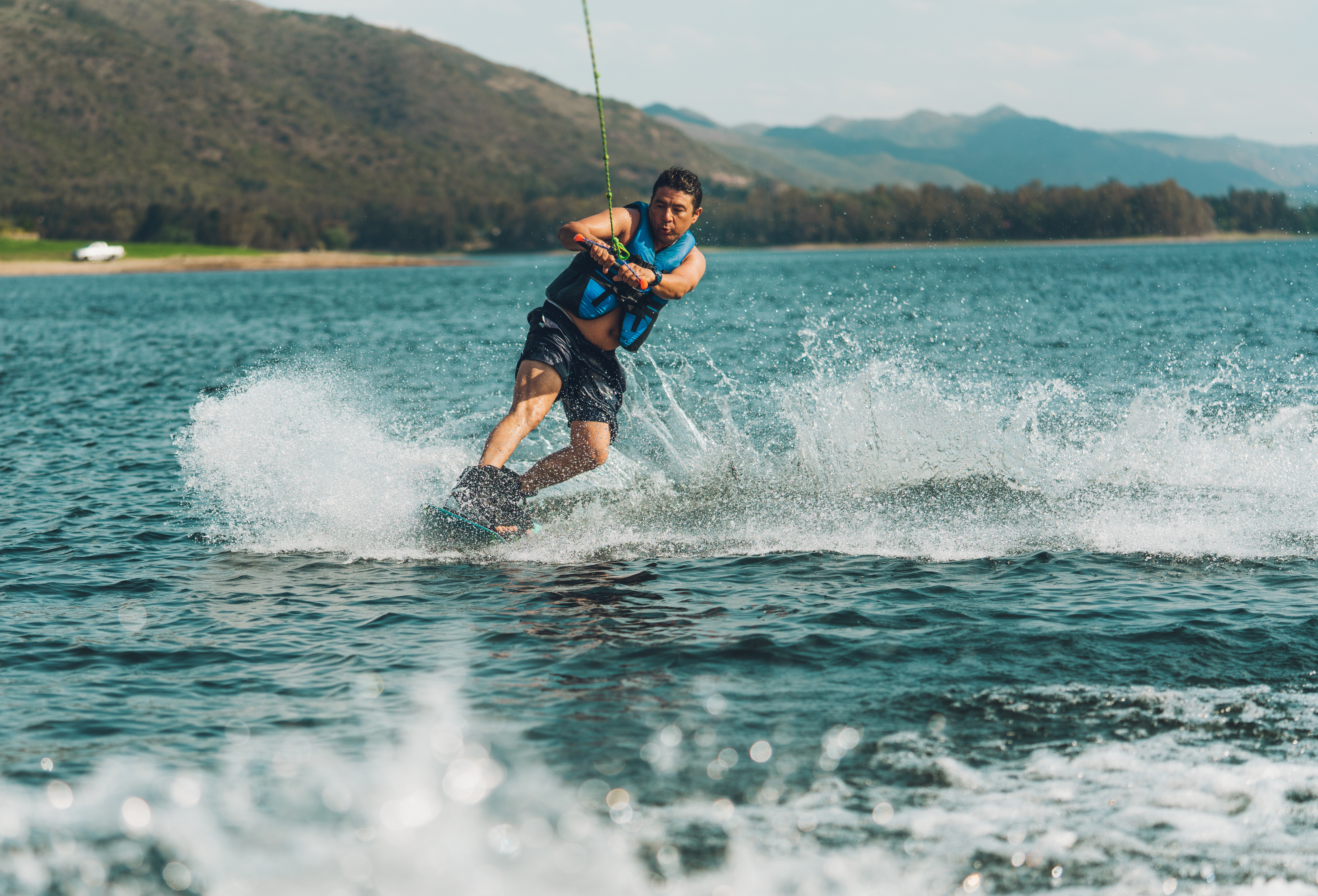 A man wearing a PFD life jacket while water skiing. 