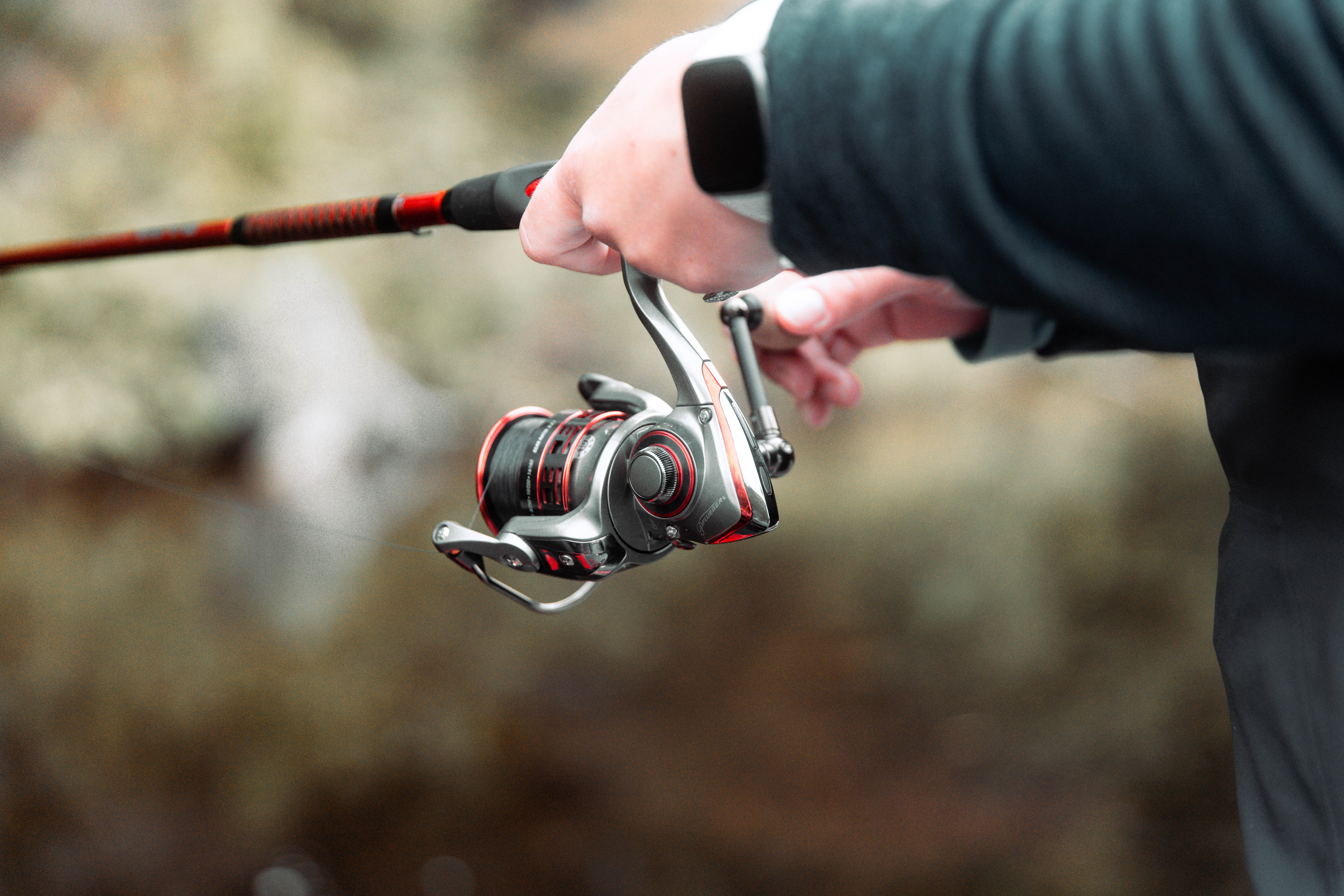 Close-up of a person holding a rod and reel, walleye fishing concept. 