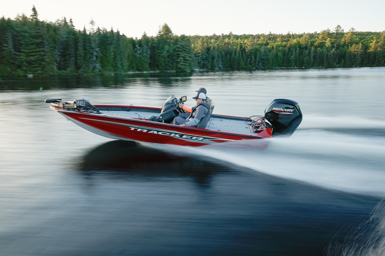 Two people on a boat speeding across the water, Lake of the Ozarks boat rental concept.