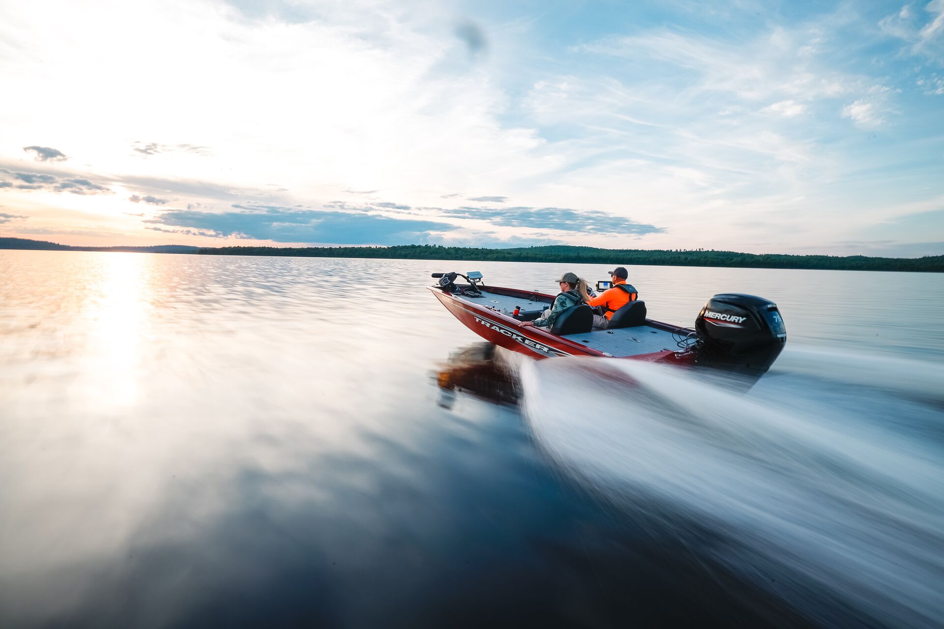 Two people on a boat speeding across the water, Lake of the Ozarks boat rental concept. 