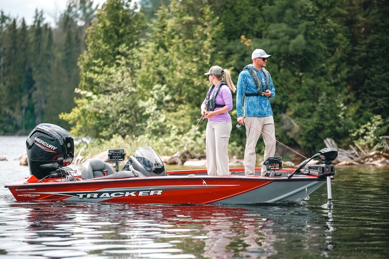 Two people on a bass boat while fishing.