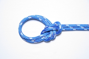Close-up of a bowline knot on a white background.